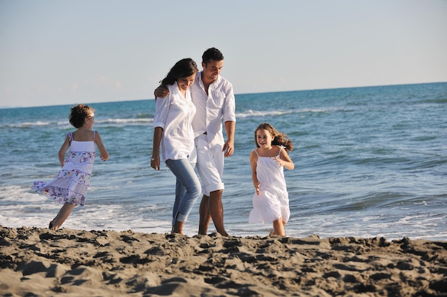 feliz familia joven vestida de blanco diviértete de vacaciones en una hermosa playa