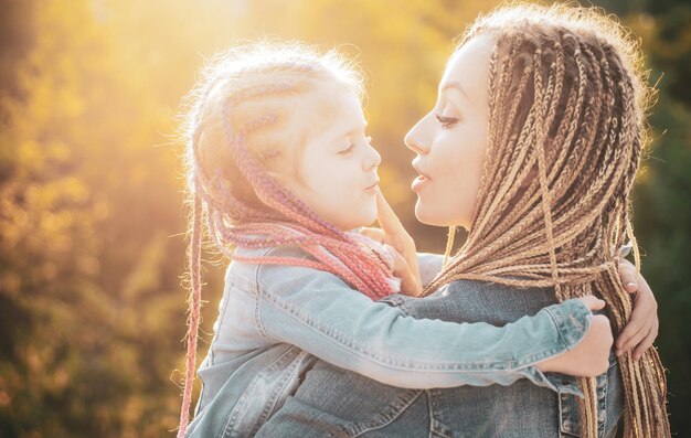 Feliz família mãe e filha criança abraçando e beijando