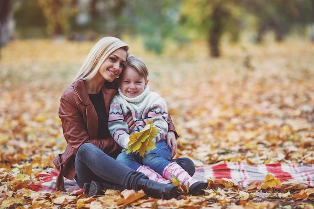 Feliz família mãe e filha durante uma caminhada no parque outono