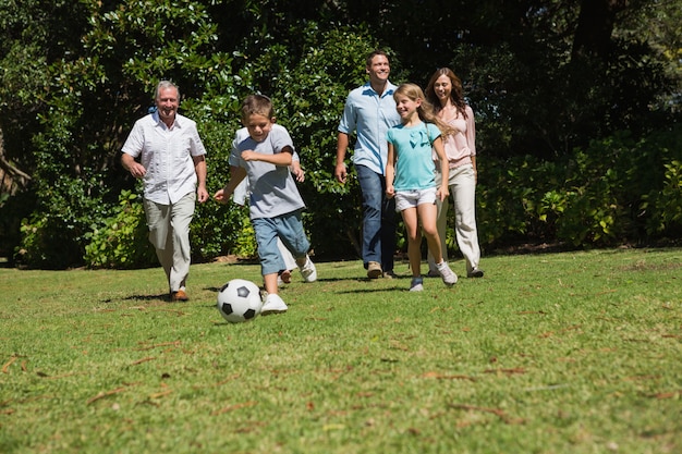 Feliz familia de multi generación jugando al fútbol