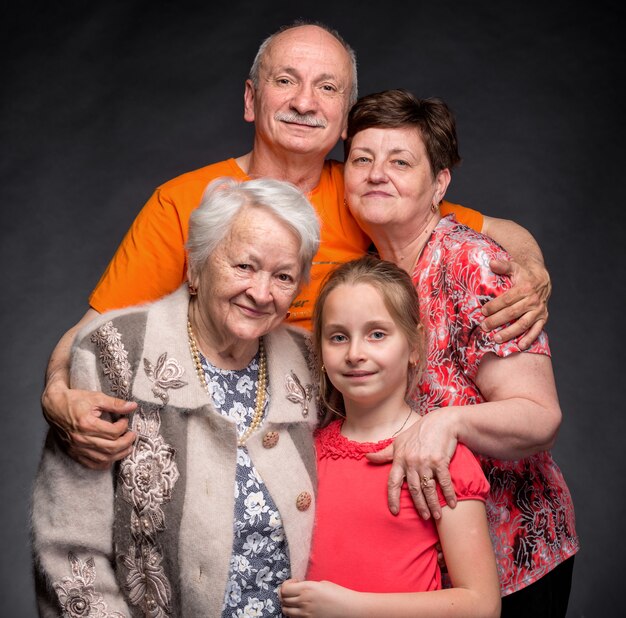 Foto feliz familia multigeneracional en una pared gris