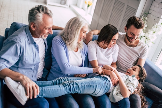 La feliz familia multigeneracional sentada en el sofá