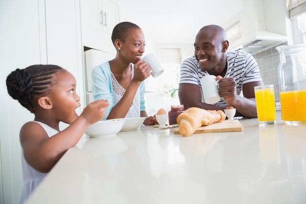 Foto feliz familia sentado y tomando el desayuno