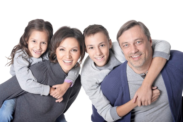 Feliz familia sonriente de cuatro posando juntos en blanco