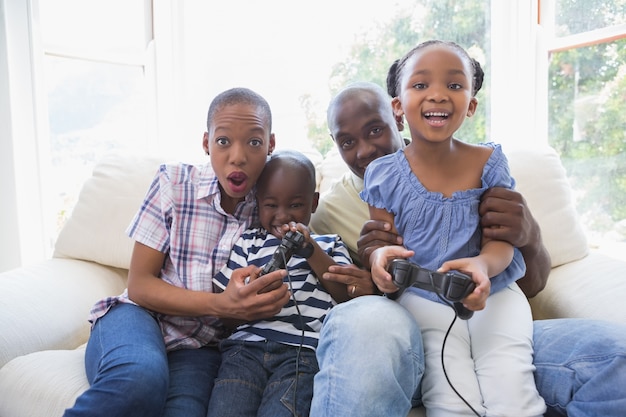 Feliz família sorrindo jogando videogames em conjunto