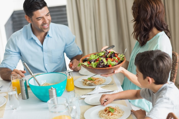 Feliz familia de tres sentados en la mesa de comedor