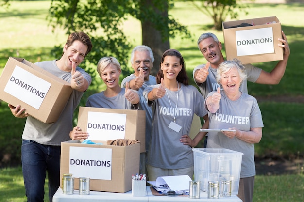 Feliz familia voluntaria con los pulgares arriba