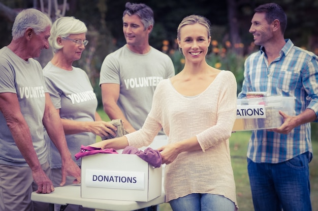 Feliz familia voluntaria que separa donaciones de animales