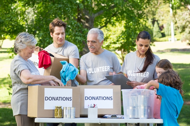 Feliz familia voluntaria que separa donaciones de animales