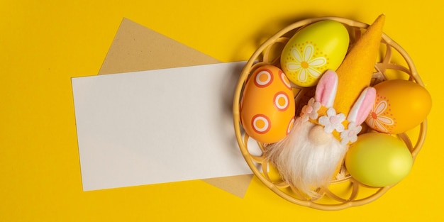 Feliz Festa de Páscoa com ovo pintado, coelho, elfo e flor em fundo amarelo Cartão de saudação