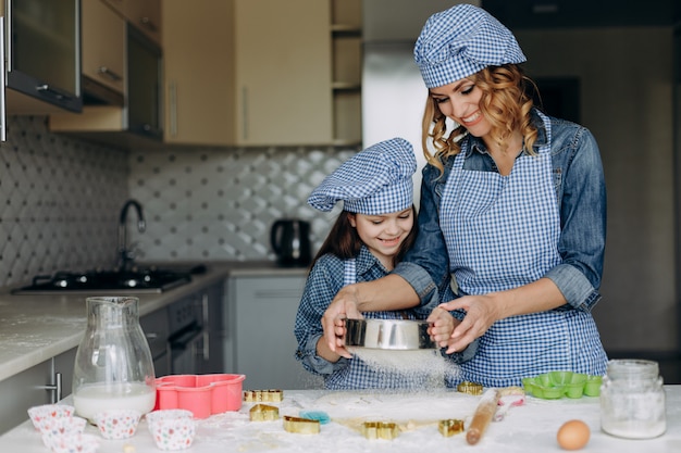 Feliz filha e mãe são agitar a massa. Conceito familiar