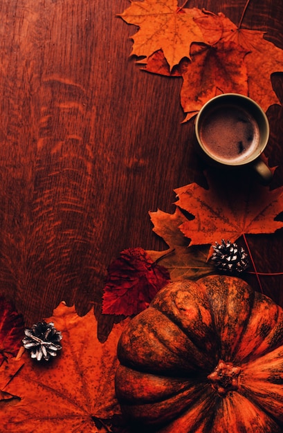 Feliz fondo de otoño de acción de gracias con calabaza, conos, taza de café y hojas