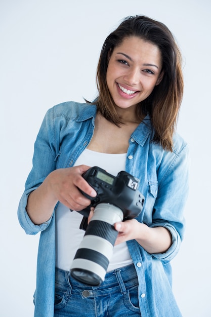 Feliz fotógrafo feminino em pé no estúdio