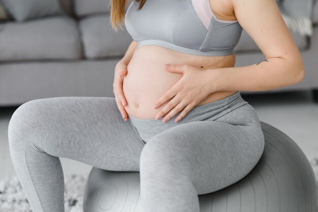 Feliz futura madre haciendo ejercicios de pilates