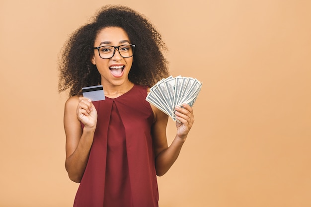 Feliz ganador. Retrato de mujer exitosa de 20 años con peinado afro con mucho dinero