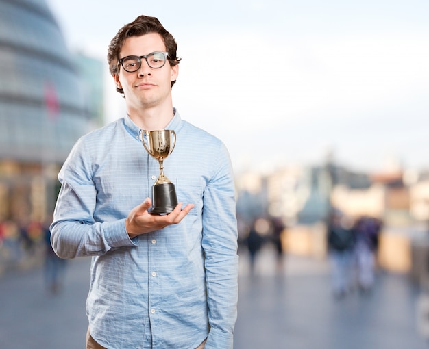 Feliz ganador sujetando una taza de oro