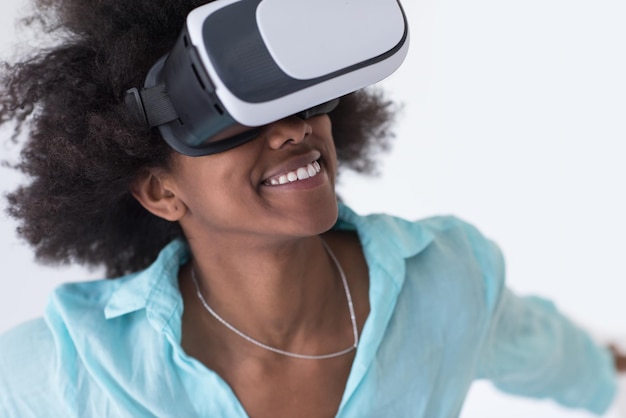 Feliz garota afro-americana obtendo experiência usando óculos de fone de ouvido VR de realidade virtual, isolados no fundo branco