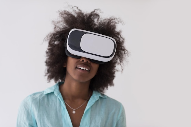 Feliz garota afro-americana obtendo experiência usando óculos de fone de ouvido VR de realidade virtual, isolados no fundo branco