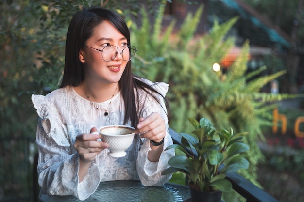 Feliz de la gente asiática mujer de negocios mantenga una taza de café informal relajado por la mañana en la cafetería, concepto de estilo de vida empresarial