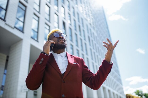 Feliz gerente de moda latino españa en chaqueta marsala en la ciudad al aire libre soleado verano buen día