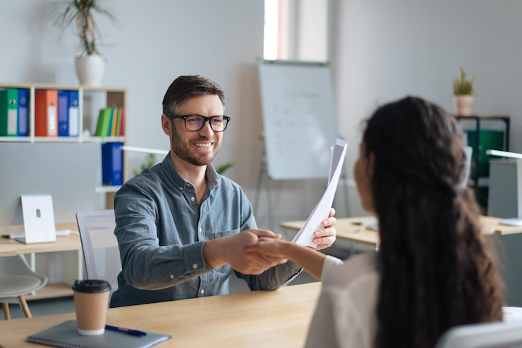 Foto feliz gerente de personal y candidata de trabajo dándose la mano después de una exitosa entrevista de trabajo