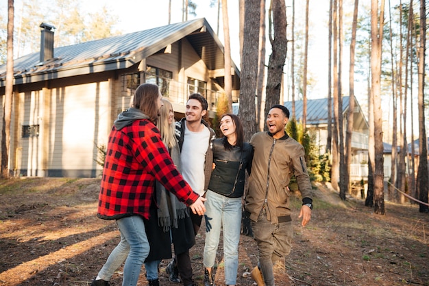 Feliz grupo de amigos caminando al aire libre en el bosque.