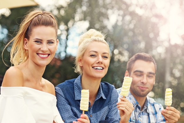 feliz grupo de amigos comiendo helado al aire libre