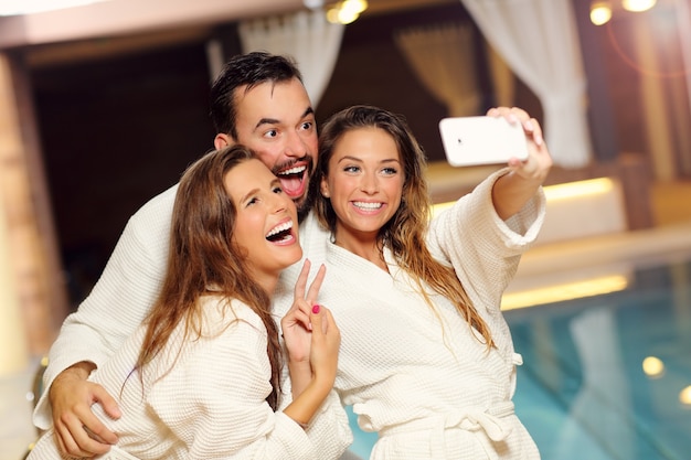 Feliz grupo de amigos relajándose en el spa de la piscina