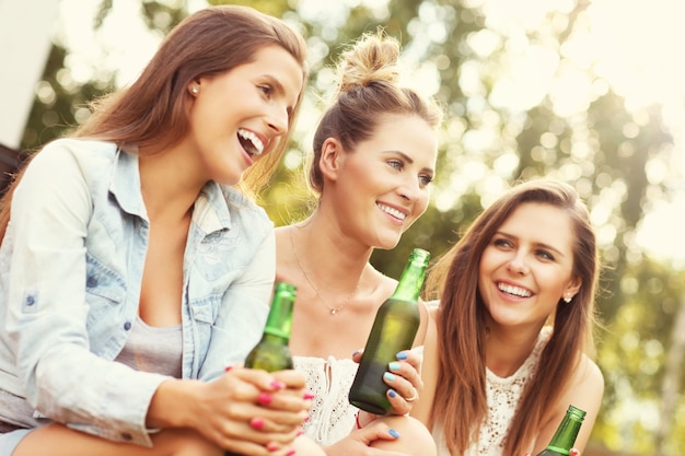 feliz grupo de amigos tomando una cerveza al aire libre