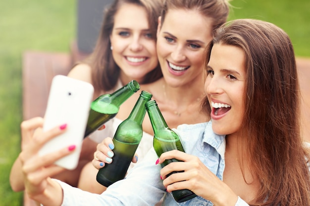 feliz grupo de amigos tomando una cerveza al aire libre