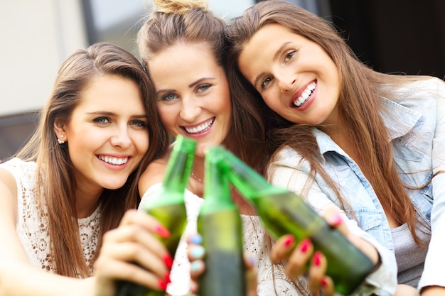 feliz grupo de amigos tomando una cerveza al aire libre