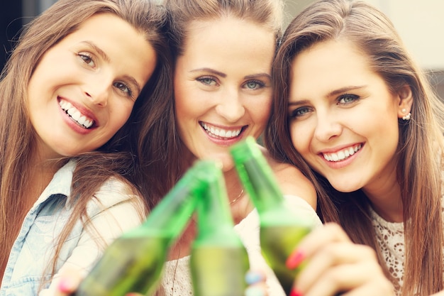 feliz grupo de amigos tomando una cerveza al aire libre