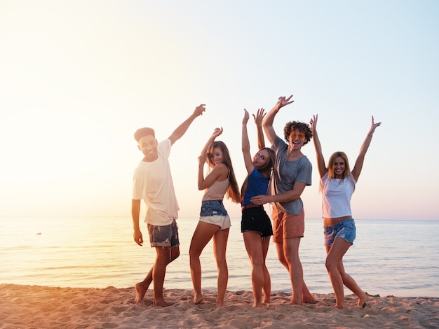 Feliz grupo de amigos erguendo as mãos para o céu