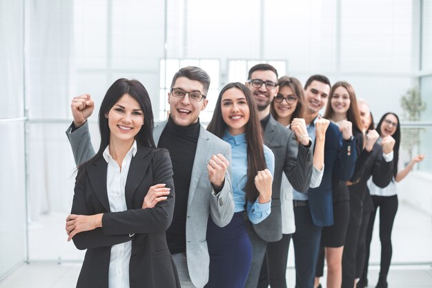 Feliz grupo de diversos jovens em pé em uma fileira. o conceito de trabalho em equipe