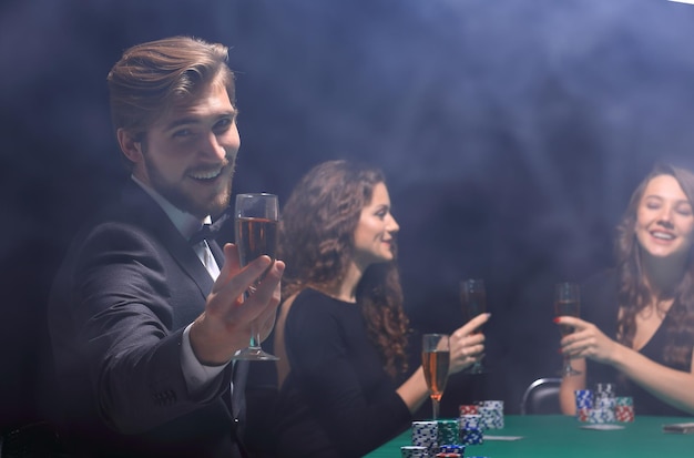 Feliz grupo de pessoas comemorando um jogo de poker bem sucedido no cassino