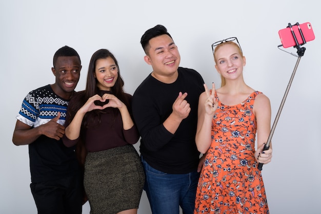 Feliz grupo diversificado de amigos multiétnicos sorrindo e posando