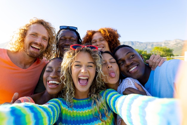 Foto feliz grupo diverso de amigos celebrando una fiesta, tomándose un selfie en el jardín. estilo de vida, amistad y fiesta, verano, sol, inalterado.