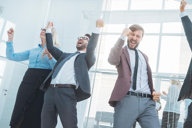 Foto feliz grupo de empleados mostrando su éxito en el lugar de trabajo