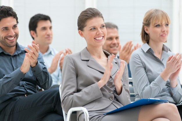 Feliz grupo empresarial de personas aplaudiendo durante una conferencia de reunión