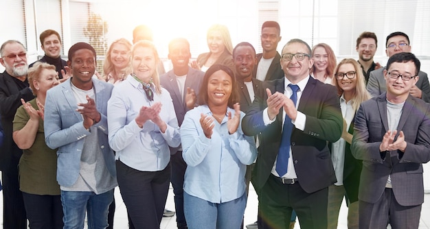 Feliz grupo de equipo de negocios aplaudiendo en el luminoso salón moderno