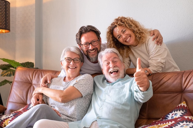 Feliz grupo de familia sentada en el sofá en casa divirtiéndose y riendo gente multigeneracional