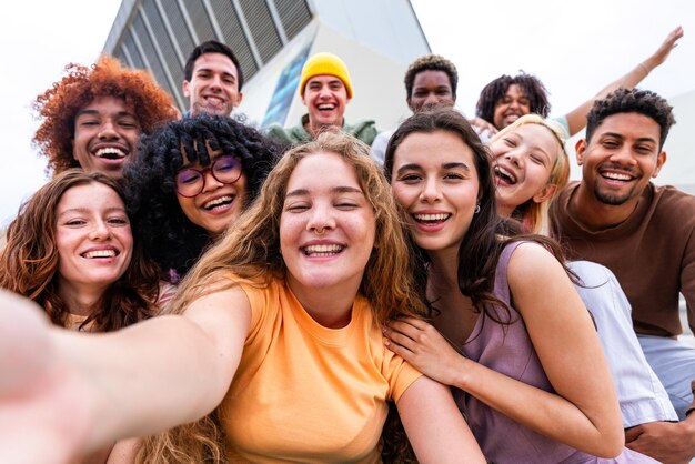 Feliz grupo multiétnico juguetón de jóvenes amigos que se unen al aire libre