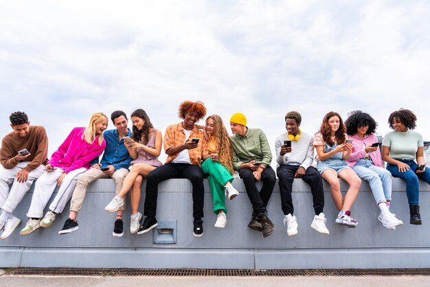 Foto feliz grupo multiétnico juguetón de jóvenes amigos que se unen al aire libre