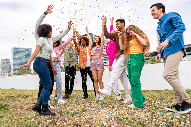 Feliz grupo multiétnico juguetón de jóvenes amigos que se unen al aire libre