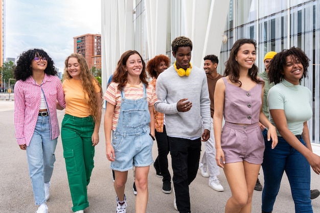 Feliz grupo multiétnico juguetón de jóvenes amigos que se unen al aire libre