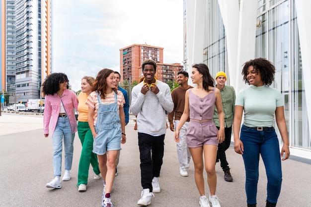 Feliz grupo multiétnico juguetón de jóvenes amigos que se unen al aire libre