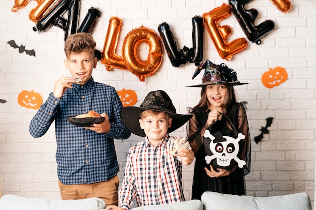 Foto feliz grupo de niños de halloween con calabazas en casa