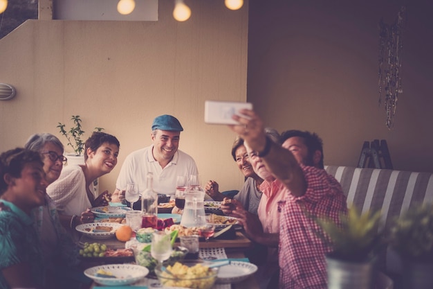 Feliz grupo de personas en amistad familiar todos juntos celebrando y teniendo una agradable cena al aire libre en casa en la terraza