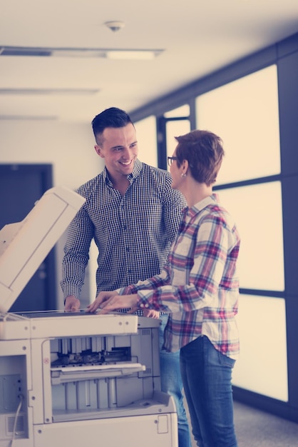 feliz grupo de personas de negocios en la oficina moderna copiar documentos en la máquina