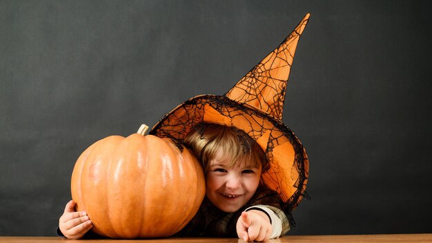 Feliz Halloween criança sorridente com abóbora para Halloween menino em chapéu de bruxa com jackolantern